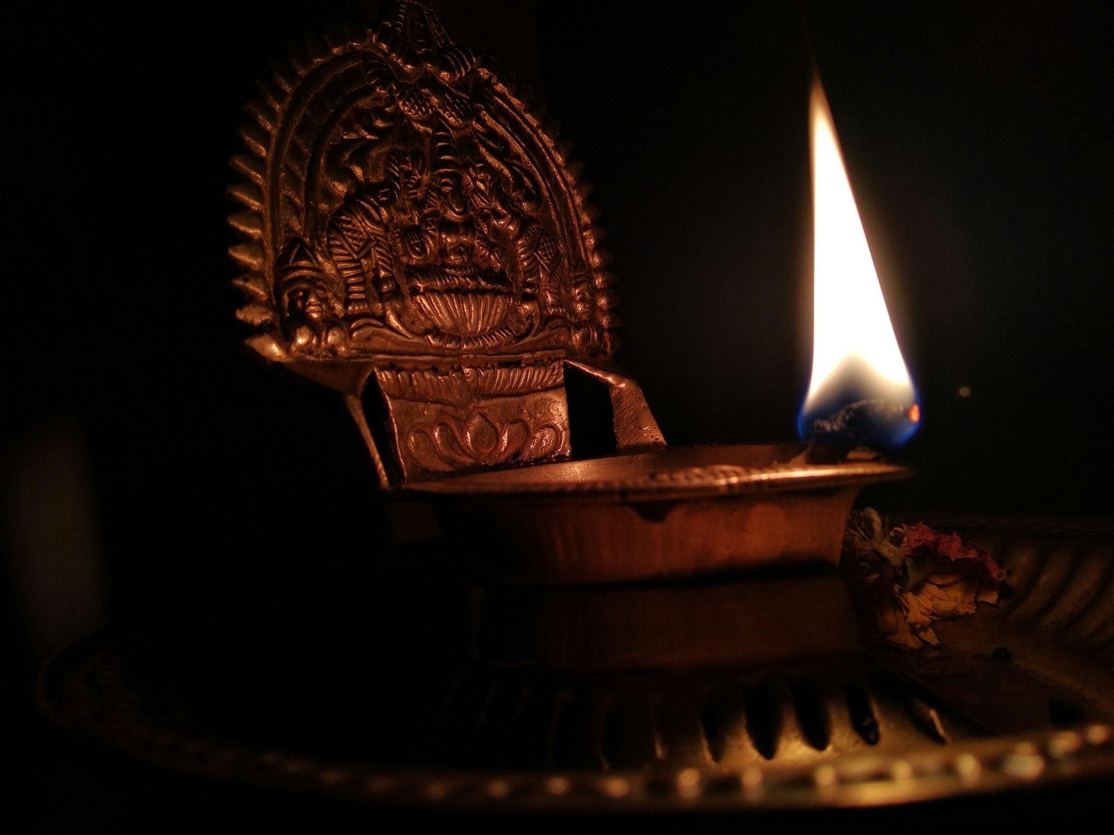 A brass lamp burning in the dark, as at a Kerala temple festival