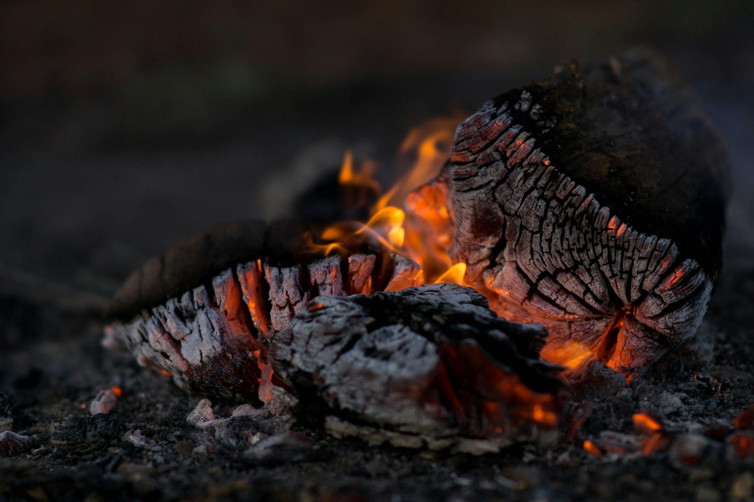 Glowing embers under burning wood